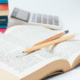 Open book with two pencils and a calculator
