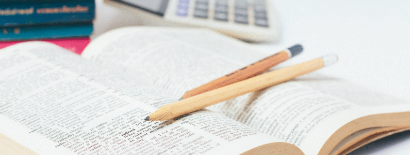 Open book with two pencils and a calculator